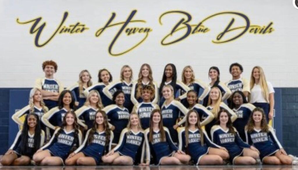 Winter Haven Blue Devils cheerleaders in navy and gold uniforms. Group photo on a court.