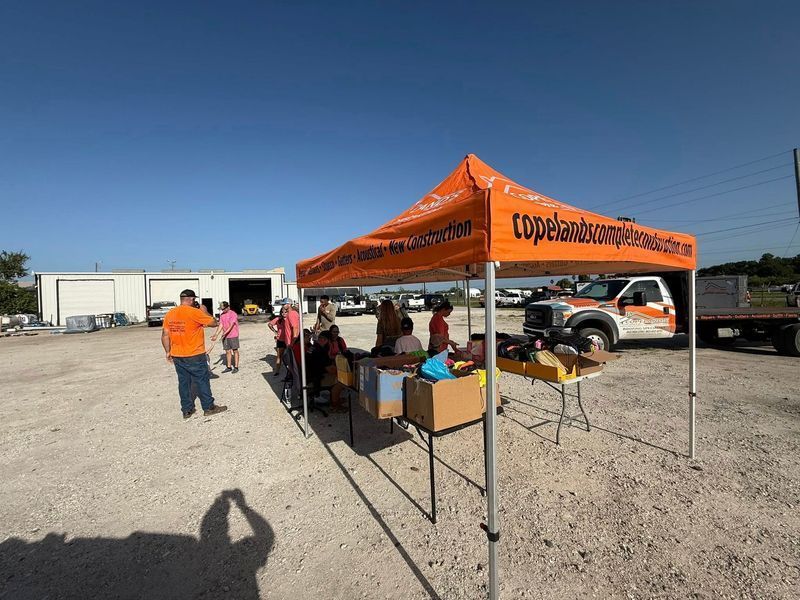 People at a Copeland Landowners Association event, under an orange tent.