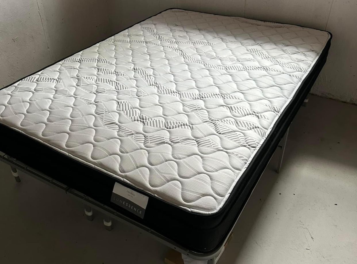 Mattress on a bed frame, with a white quilted top, black sides, and a white bed frame.