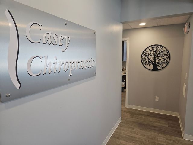 Office hallway with a wall sign reading “Cissy Chiropractic” and a tree wall decoration.