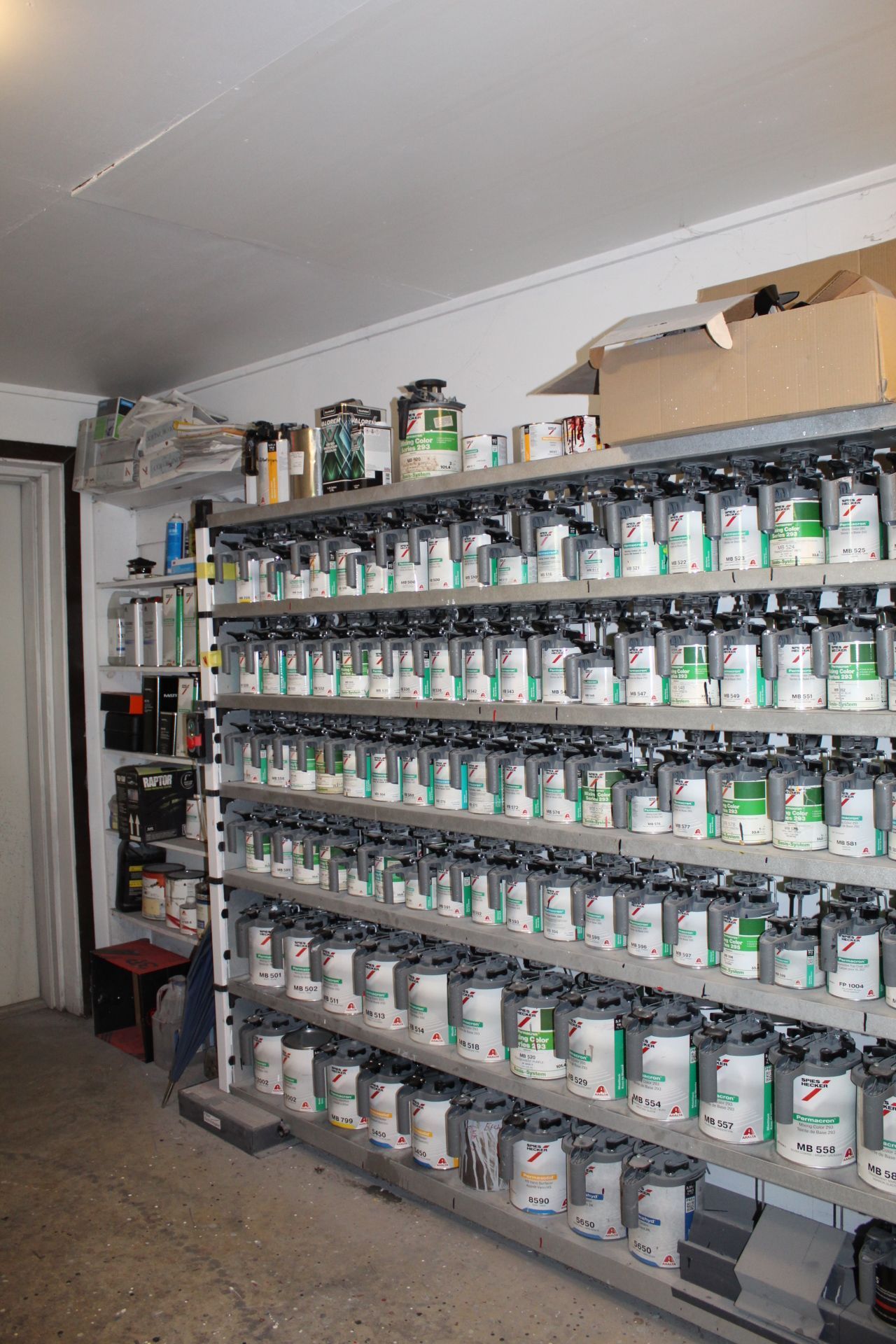 A room filled with shelves filled with bottles of paint.