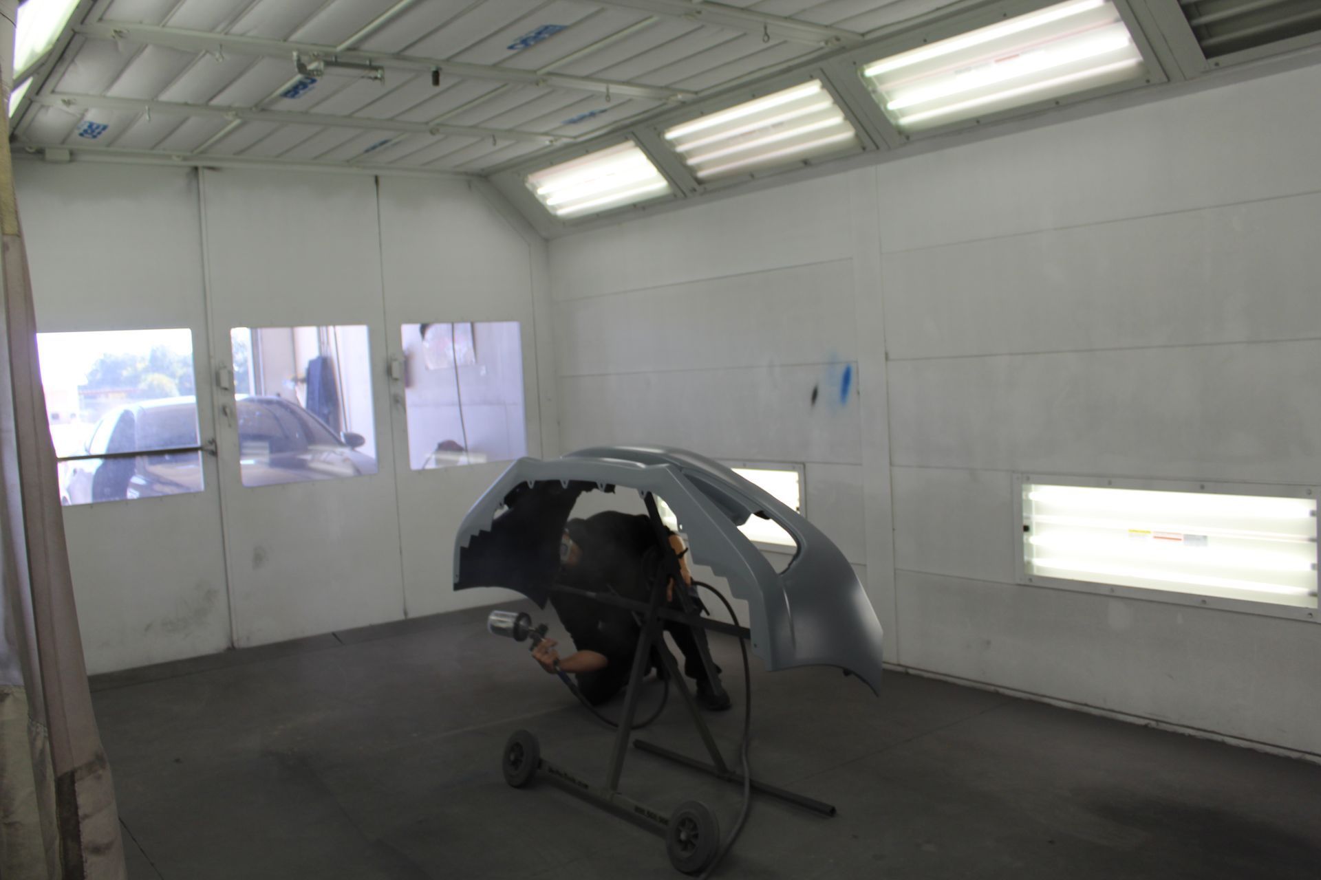 A car is being painted in a paint booth