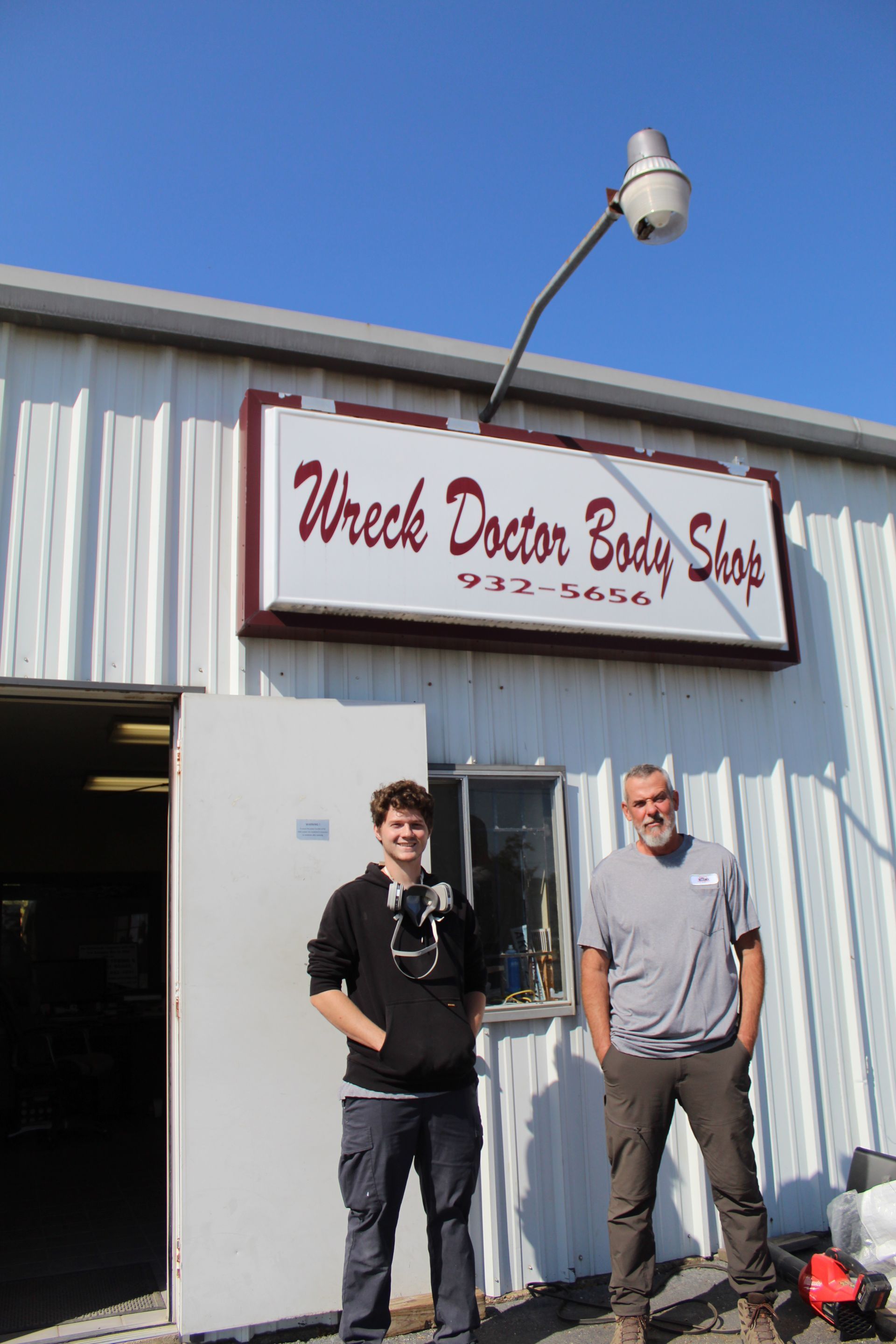 Two men are standing in front of a shop