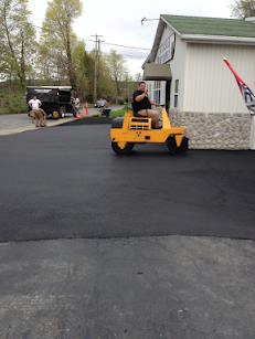 A man is riding a yellow tractor in a parking lot