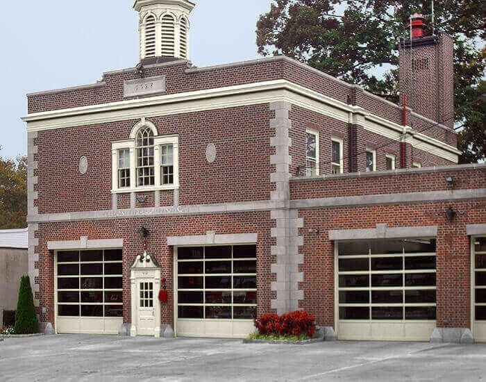 Brick fire station with three garage doors and a small cupola.
