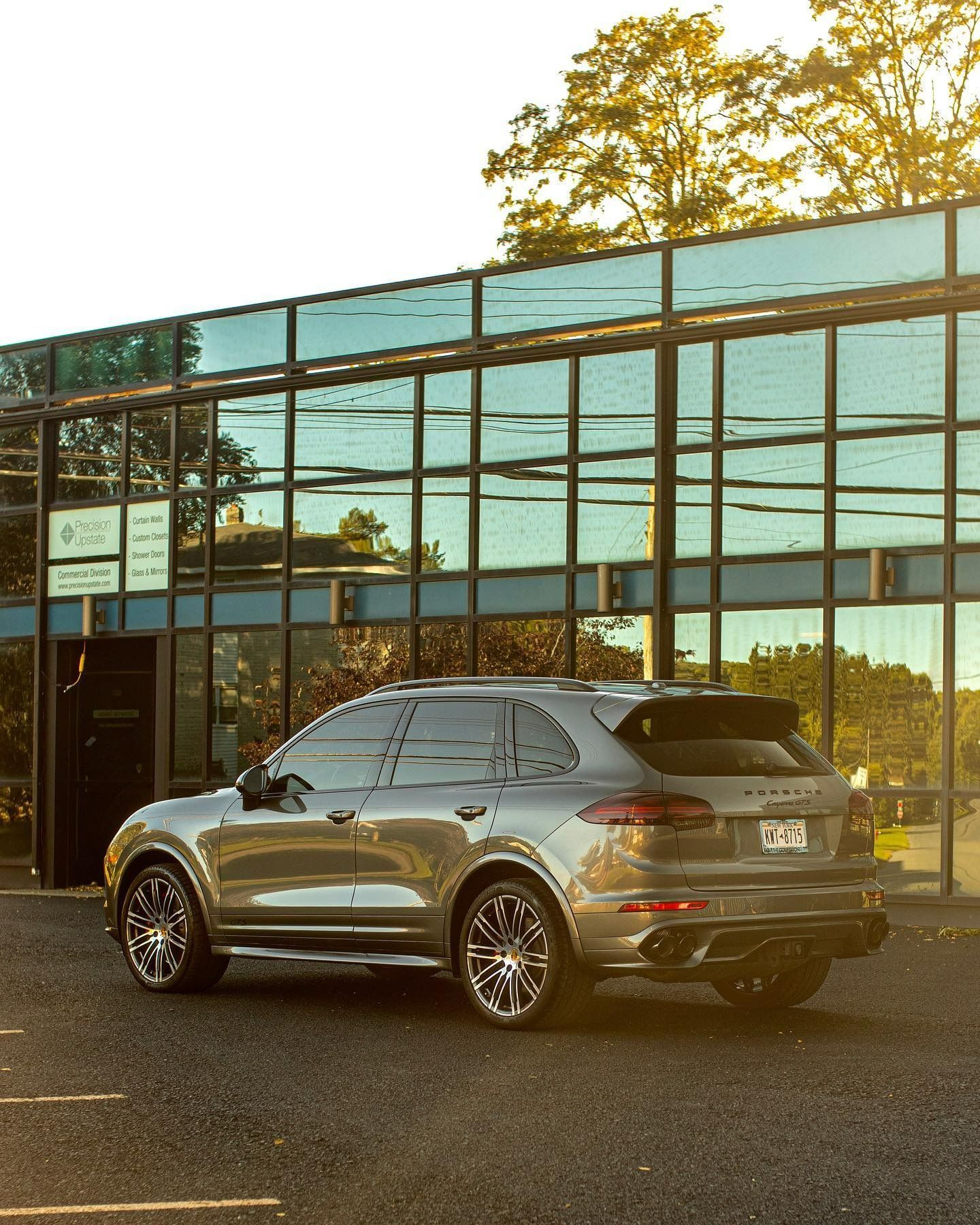 a porsche cayenne is parked in front of a building