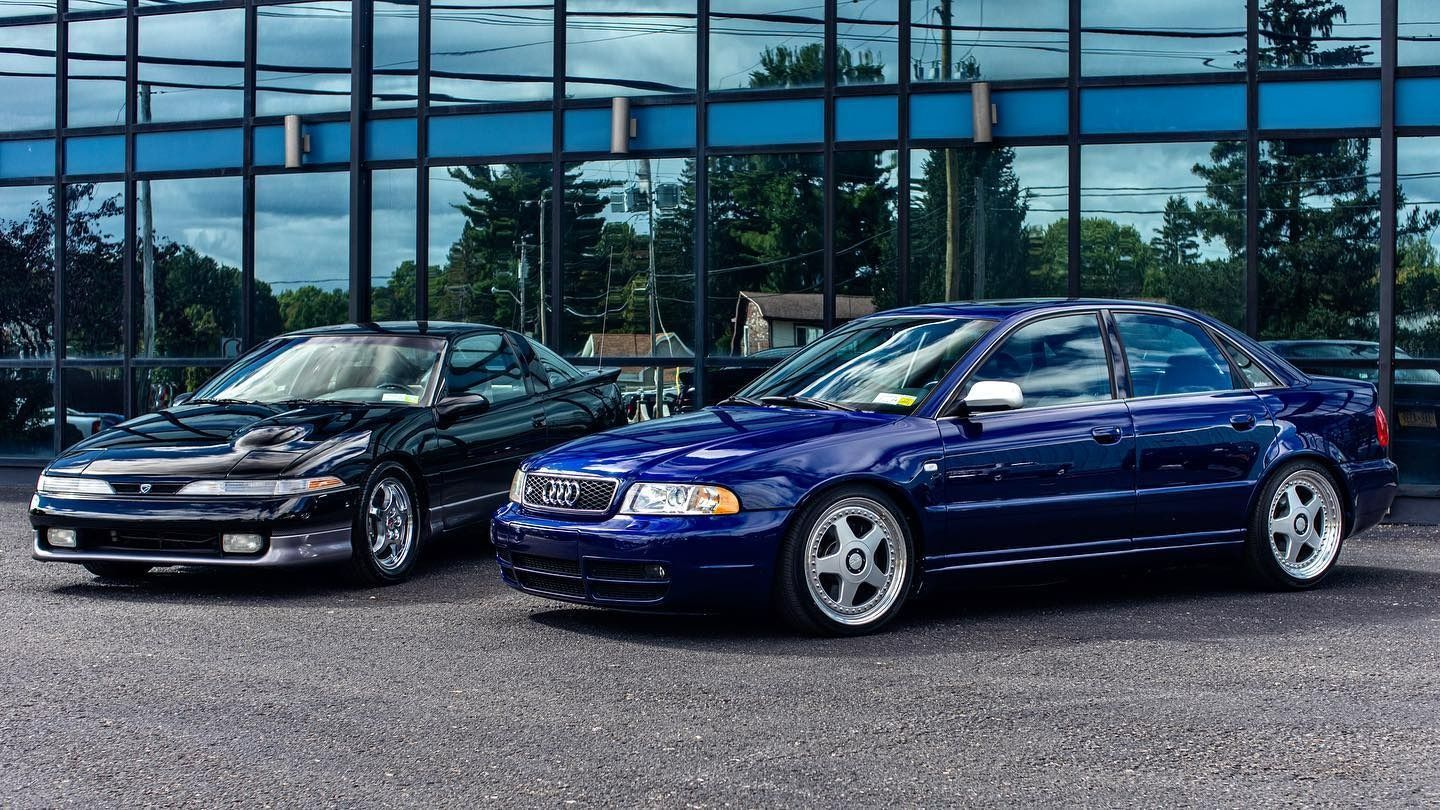 two blue cars are parked in front of a building