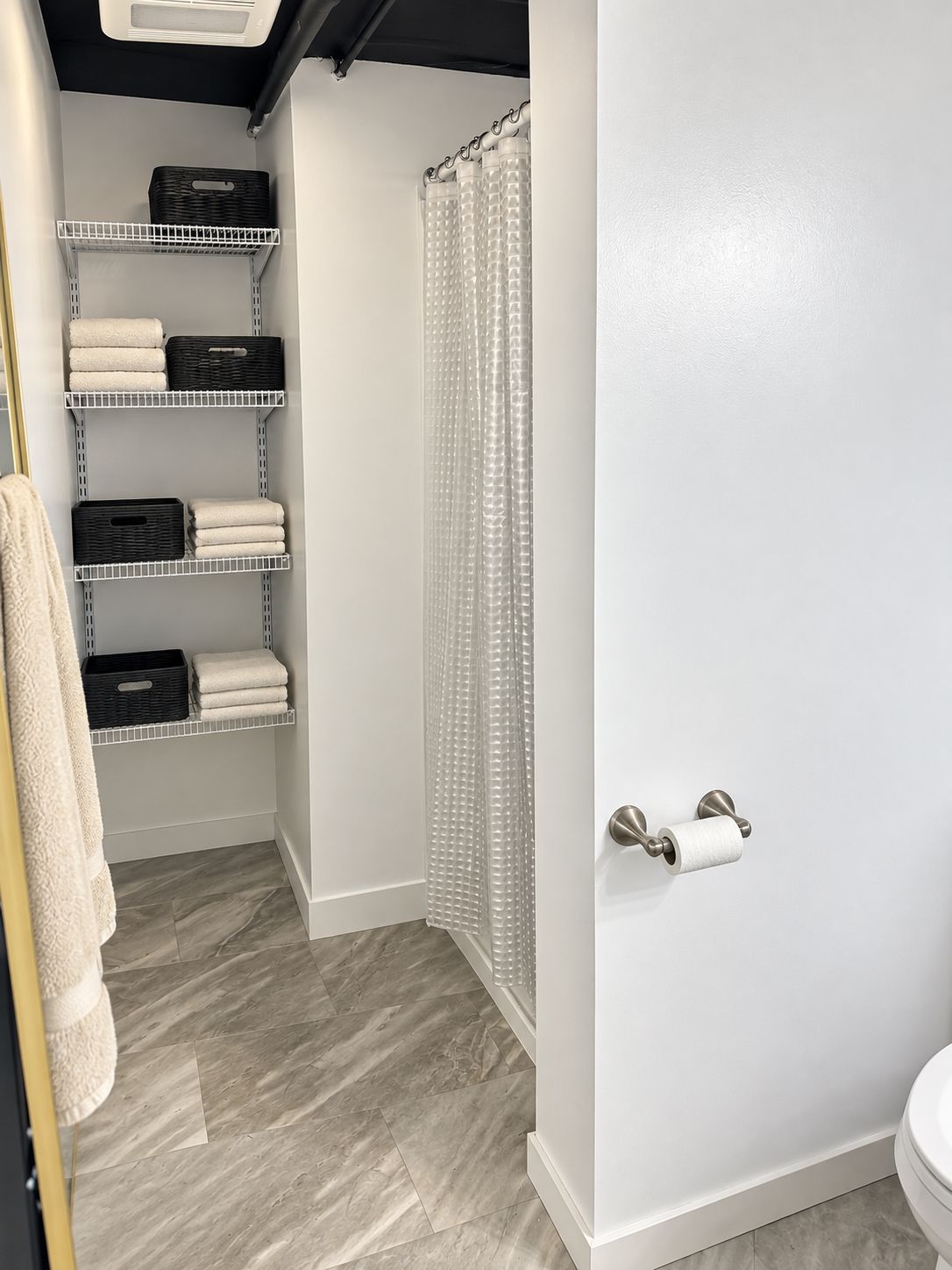 Walk-in closet with wire shelves, storage bins, and a mirrored sliding door partly open