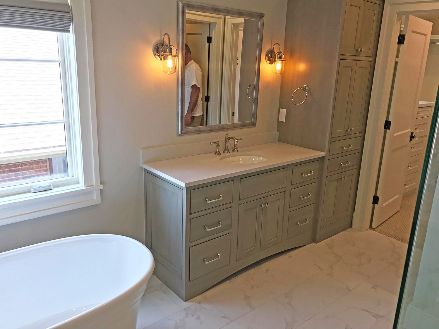 Bathroom with gray vanity, white countertop, and freestanding tub.