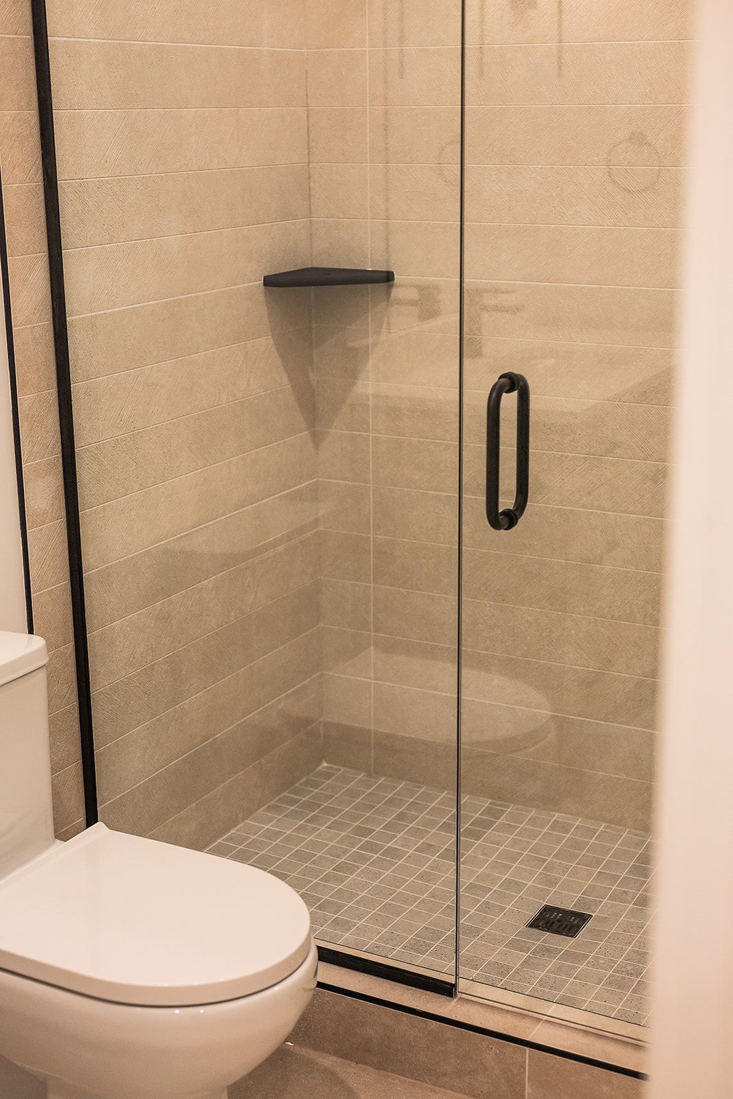 Modern bathroom with a glass shower enclosure and a toilet.