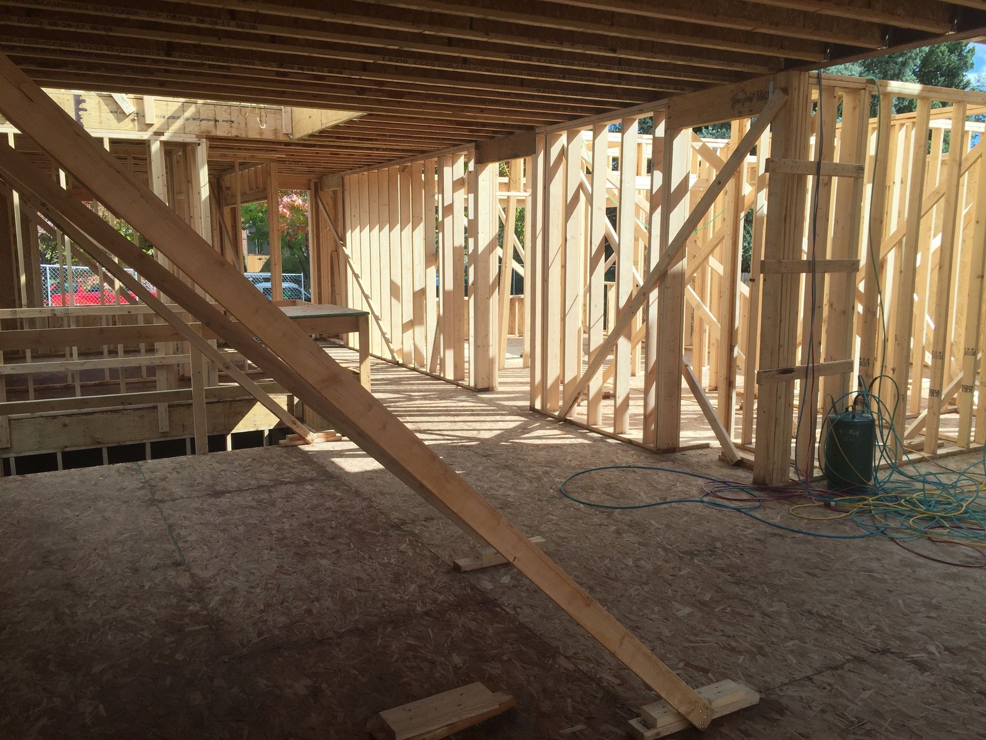 Wooden framework of a building under construction, interior view with studs and beams.