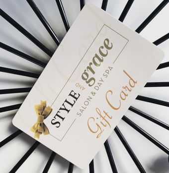 Gift card for Style and Grace Salon and Day Spa, cream colored card with gold text and a gold bow.
