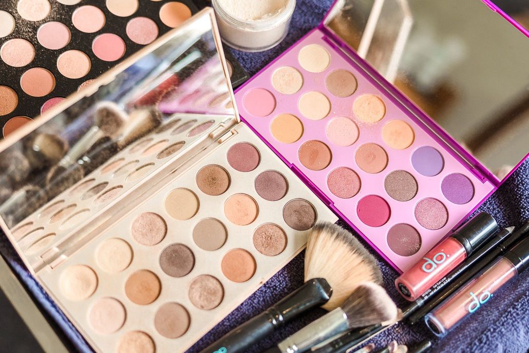 Makeup palettes with various eyeshadow colors and makeup brushes.