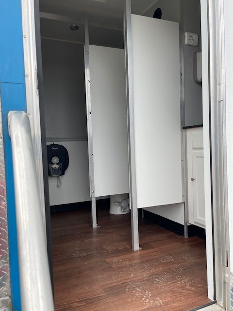 Restroom trailer with two stalls and a toilet.