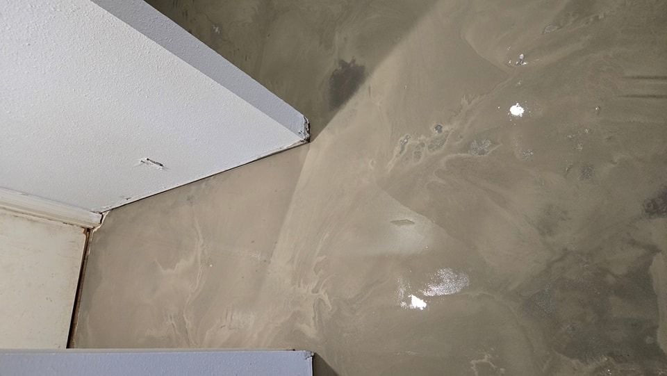 Gray and beige epoxy floor with swirls, near white wall corners.