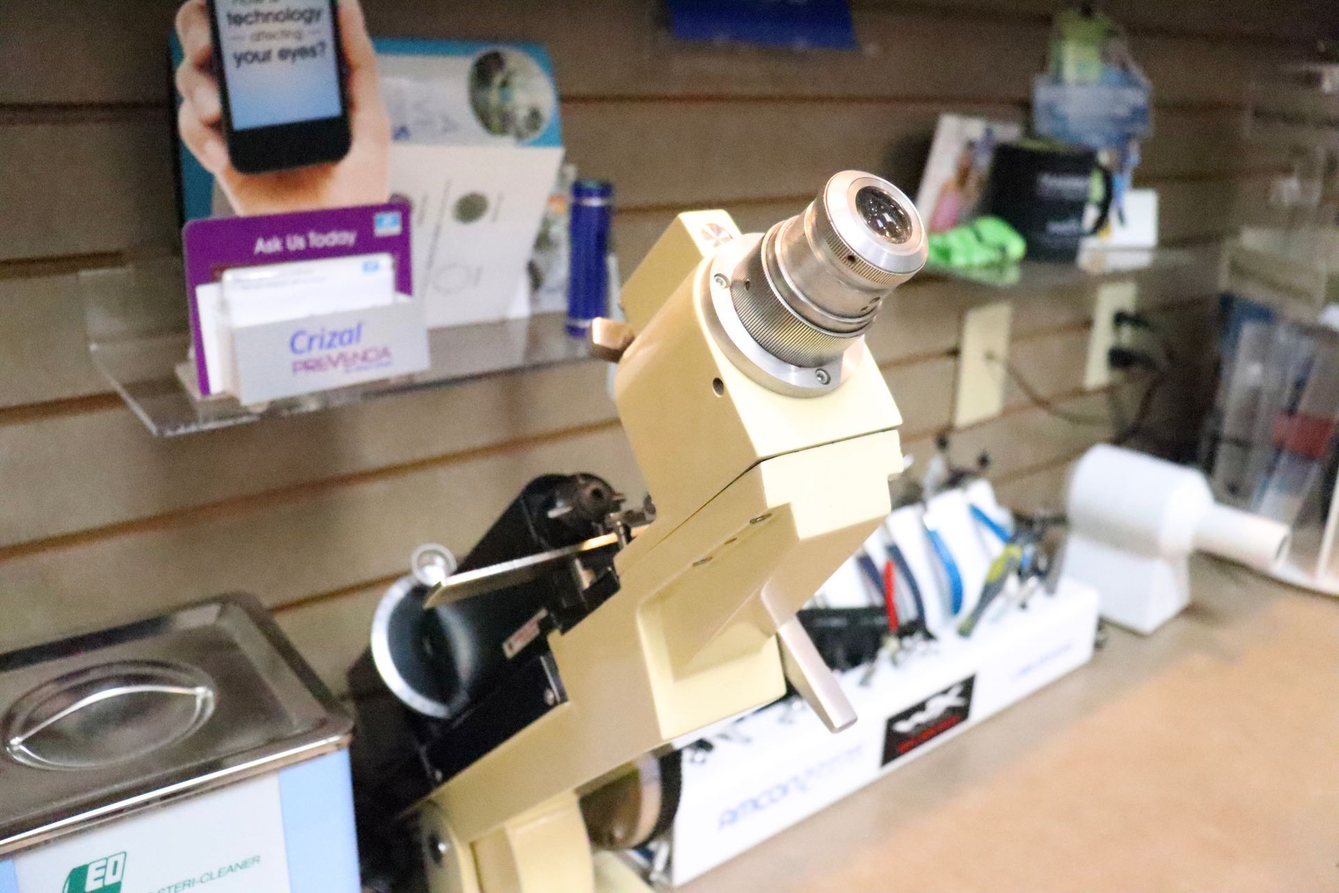 A microscope is sitting on a table next to a box of tissues