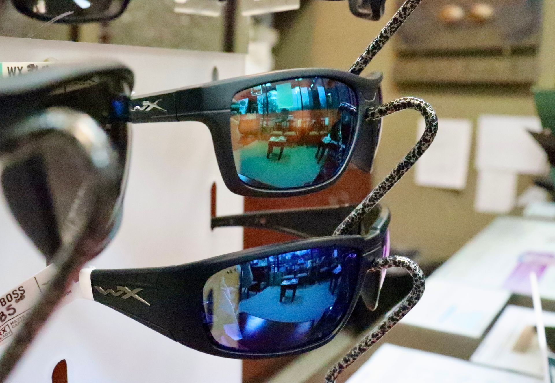 Two pairs of sunglasses are hanging on a display