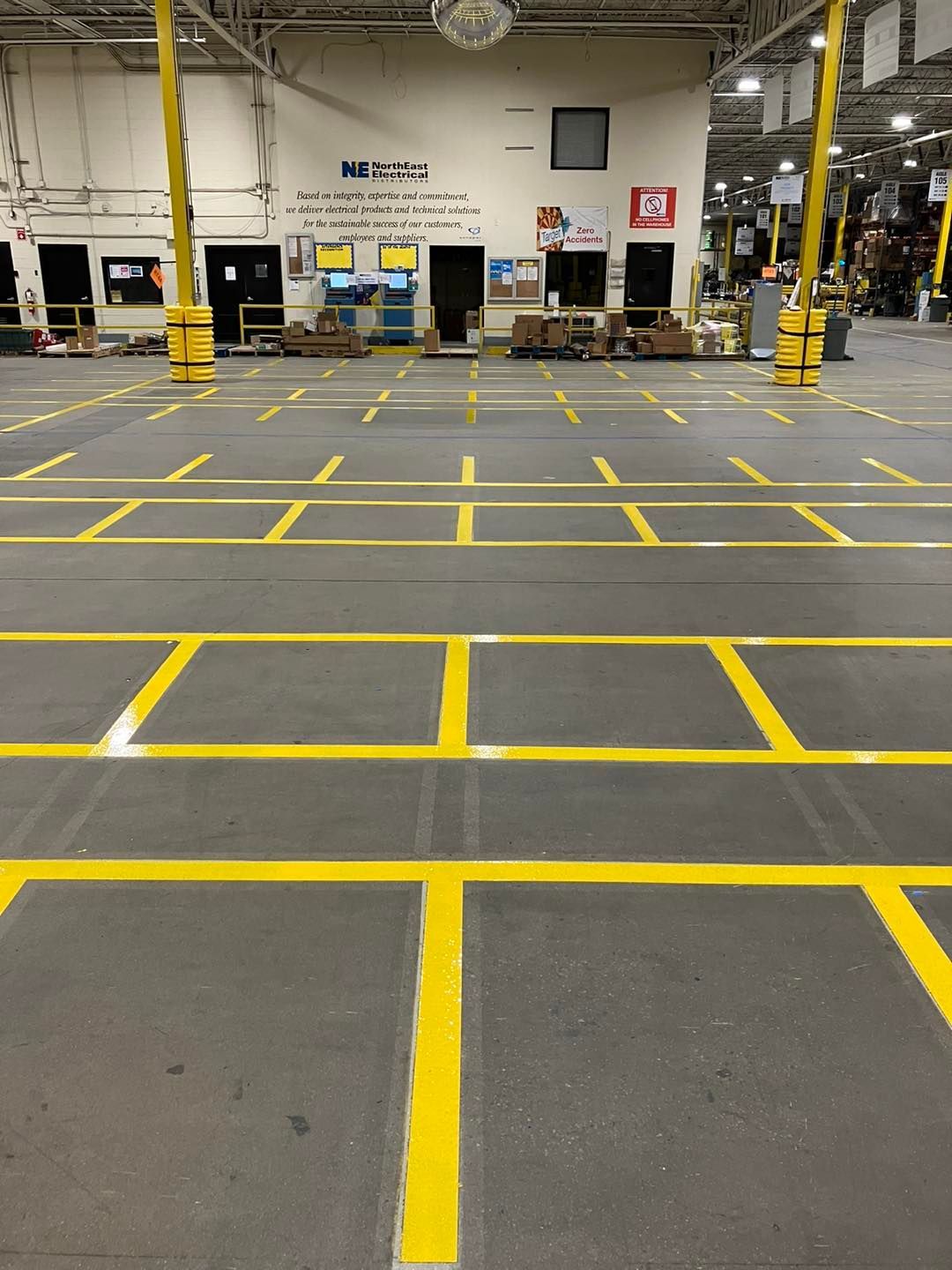 Yellow floor markings defining work areas inside a warehouse.