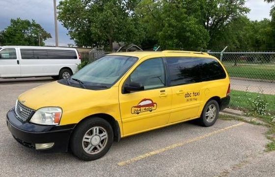 A yellow minivan is parked in a parking lot