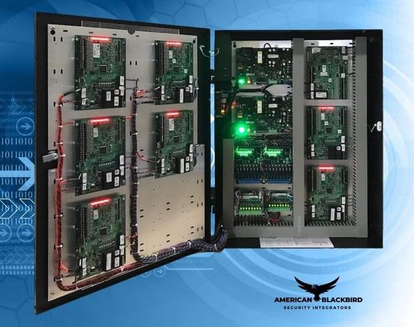 White security camera mounted outdoors, focused on greenery.