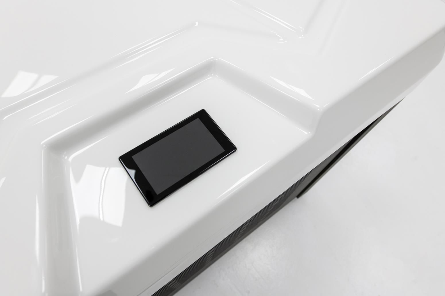 A white angled surface with a small, dark tablet nestled in a recessed area.