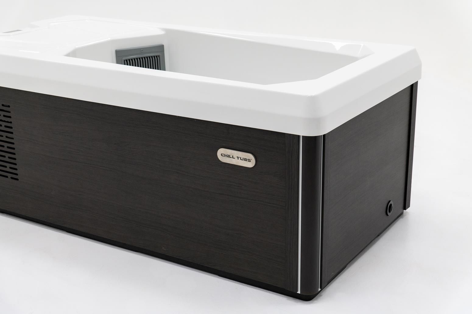 Black and white portable ice bath with a white interior and a dark wood-grain exterior.