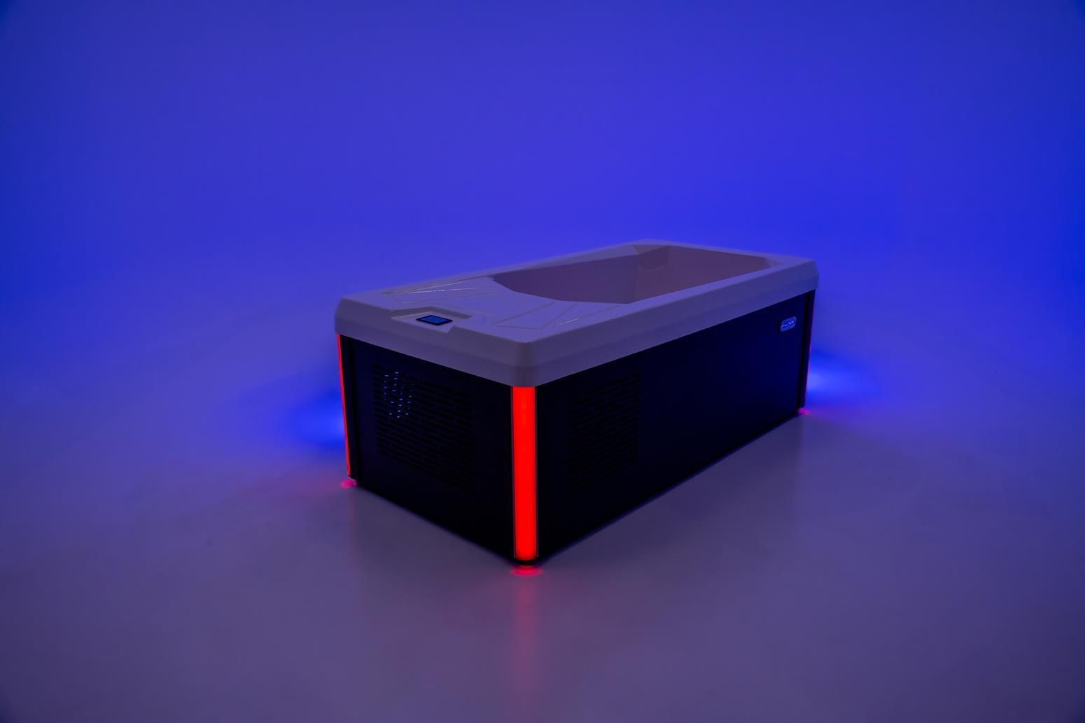 A rectangular, black device with a white top, red and blue glowing lights.