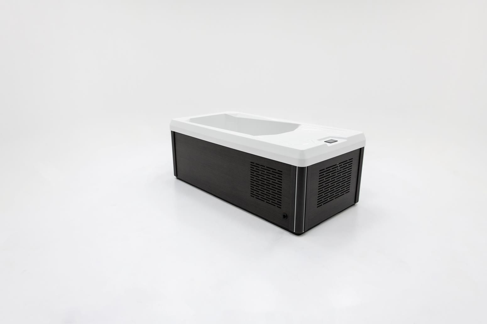 Black and white rectangular device with air vents; likely electronic equipment on a white surface.
