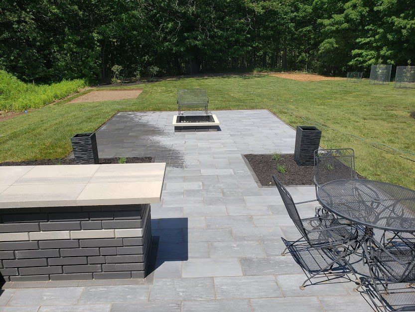 Backyard patio with fire pit, seating area, and landscaping.