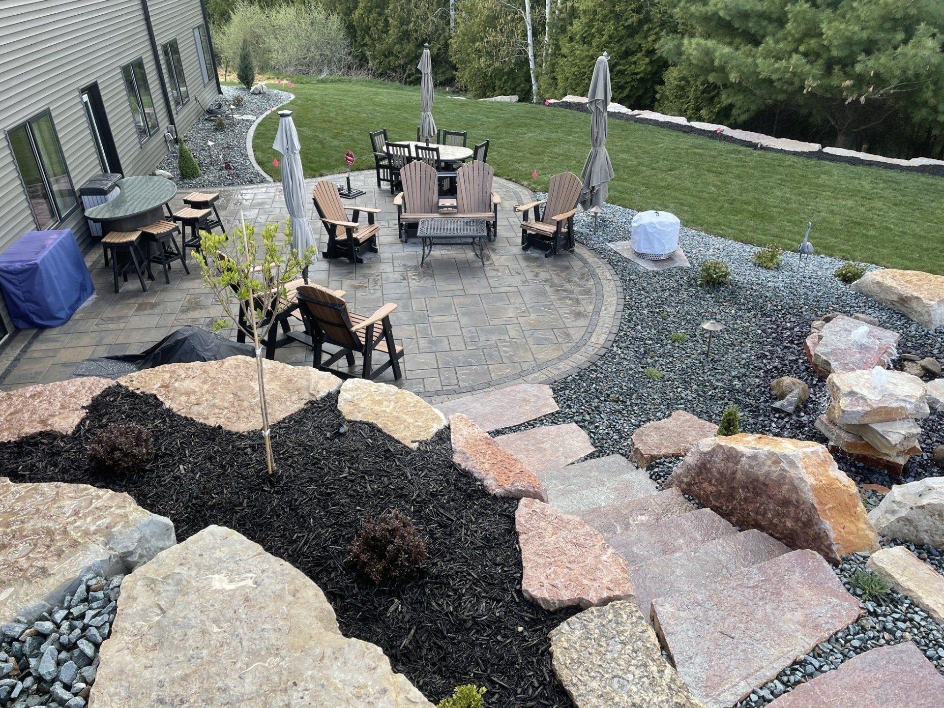 Outdoor patio with stone steps, seating areas, and a landscaped yard.