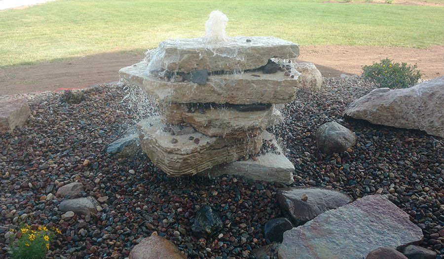 Water fountain with stacked, layered stone feature; water flowing.