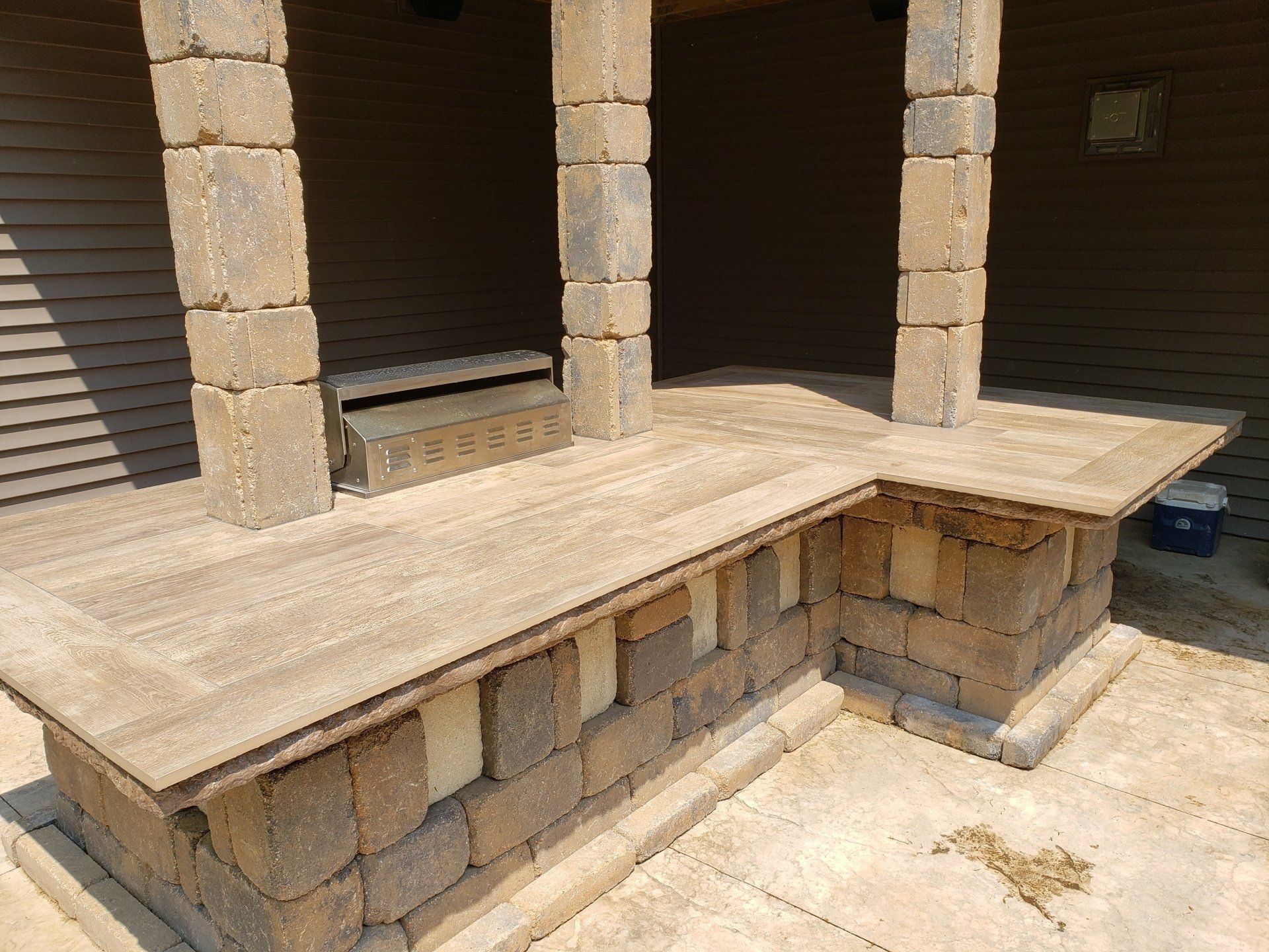 Brick patio with pillars and counter, built into a building's exterior.