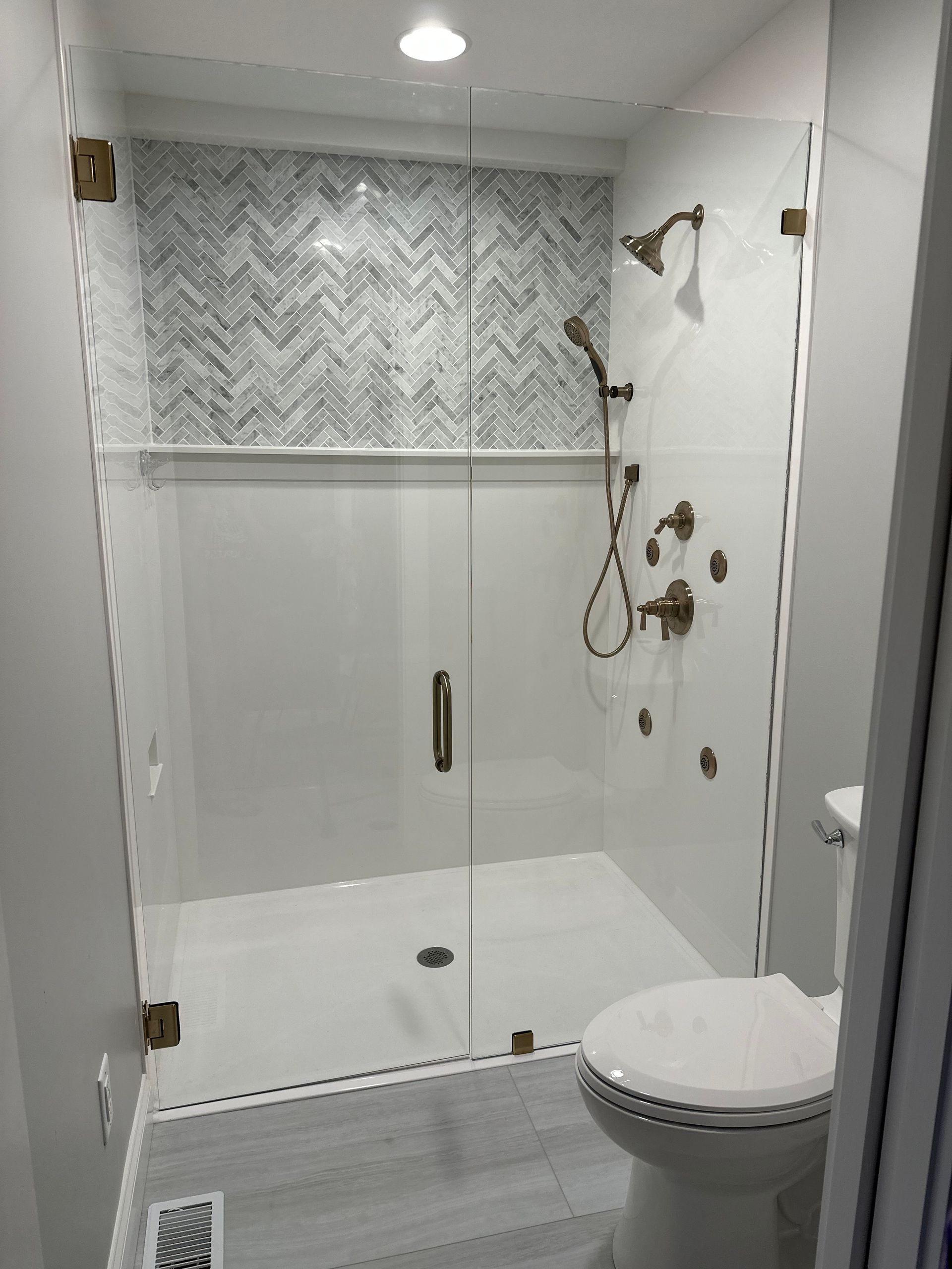 a bathroom with a toilet and a shower with a glass door