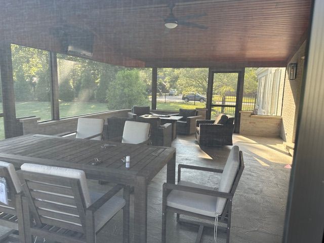 A screened in porch with a table and chairs
