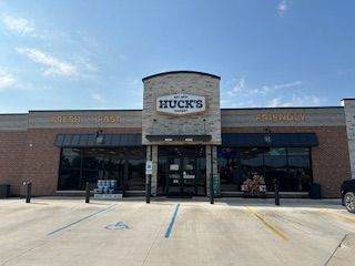 The front of a Huck's grocery store with a handicapped parking spot in front of it.