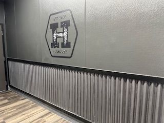 A hallway with a metal wall and a sign on the wall.