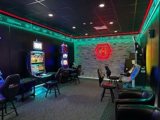 A room with a lot of chairs, tables, and slot machines.