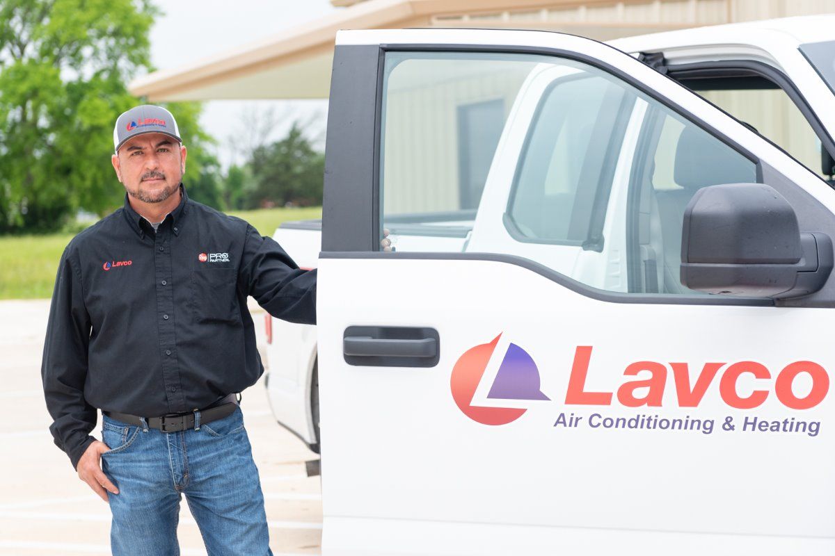 Man in Lavco uniform beside a company truck.