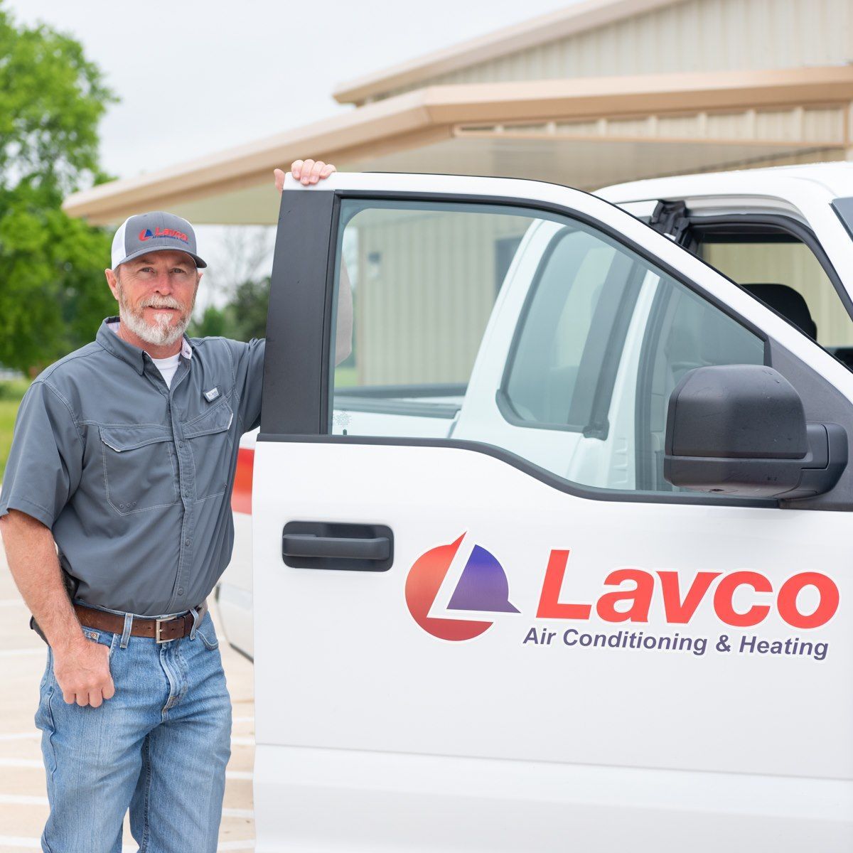 Man in work clothes beside a white truck with 
