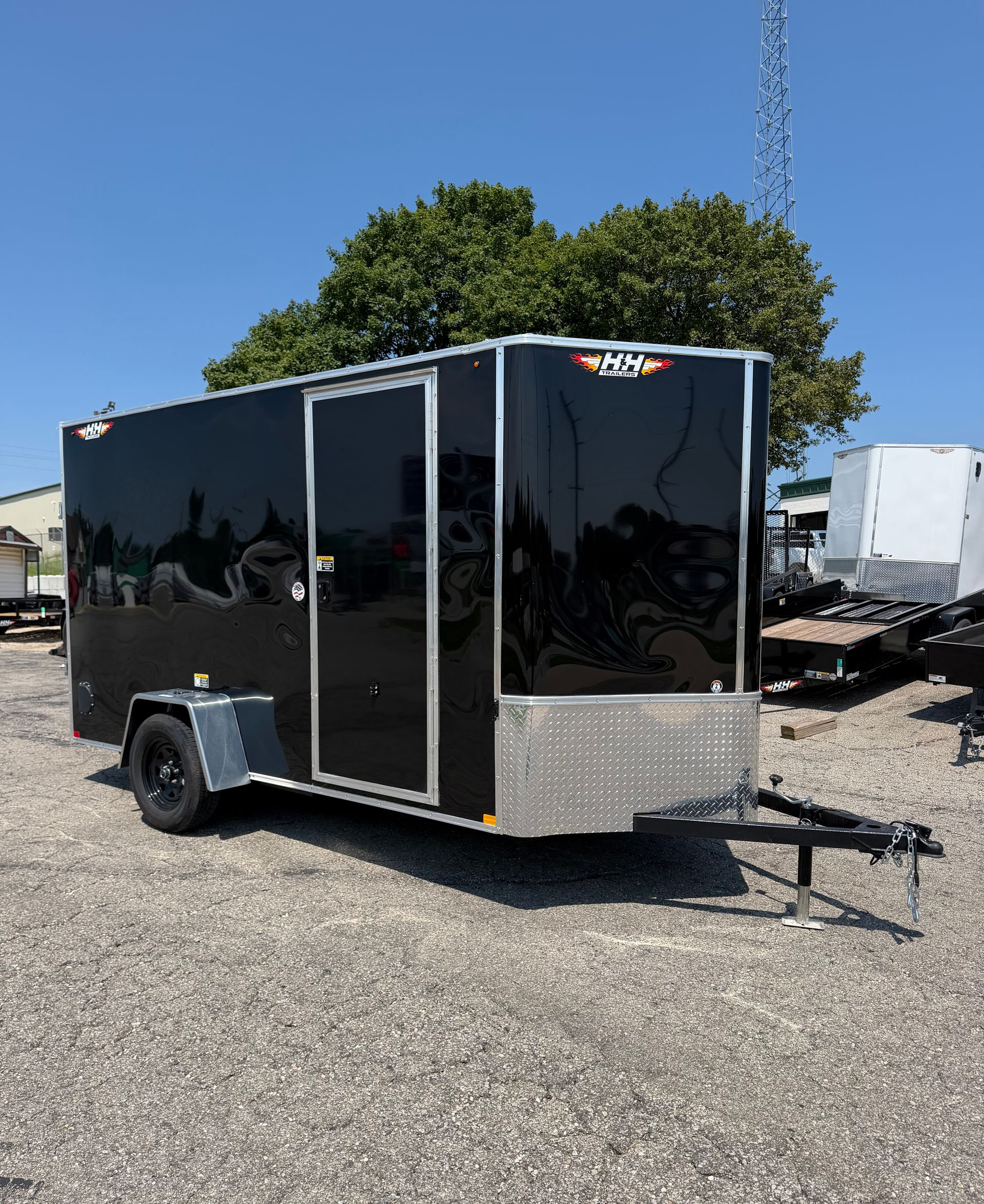 Black enclosed cargo trailer with diamond plate front and white wheels