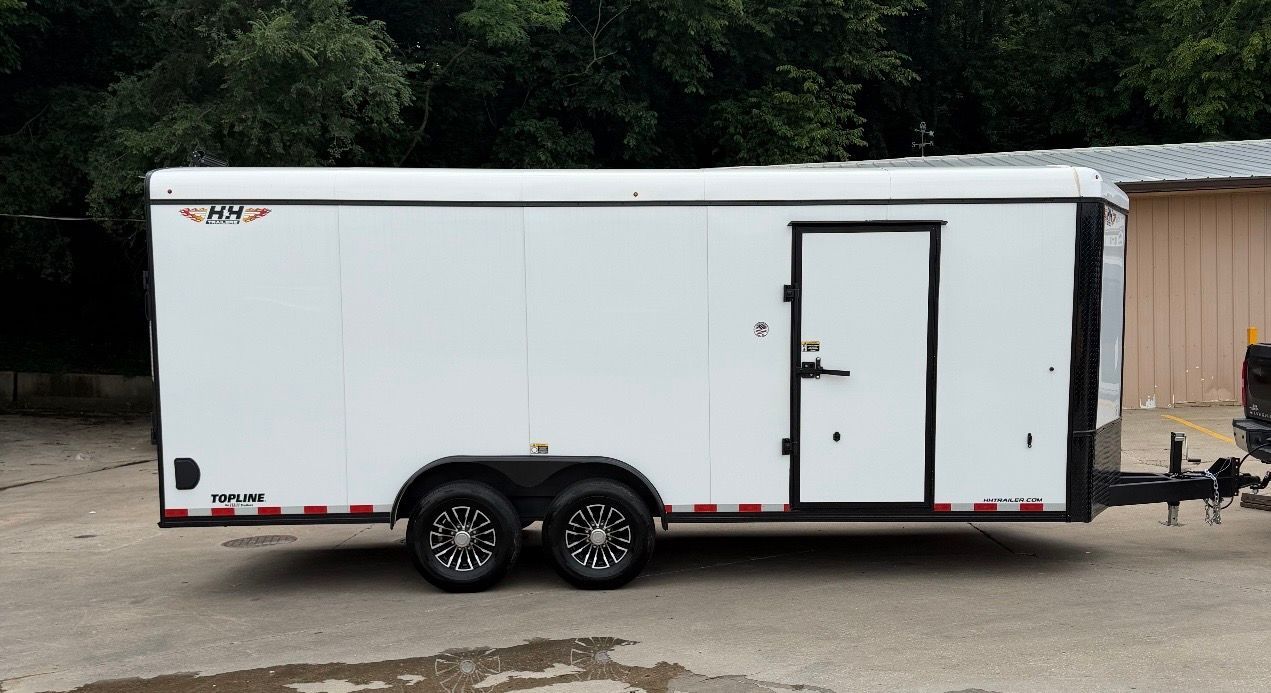 Black enclosed trailer with two wheels, a door, and a silver frame against a cloudy sky