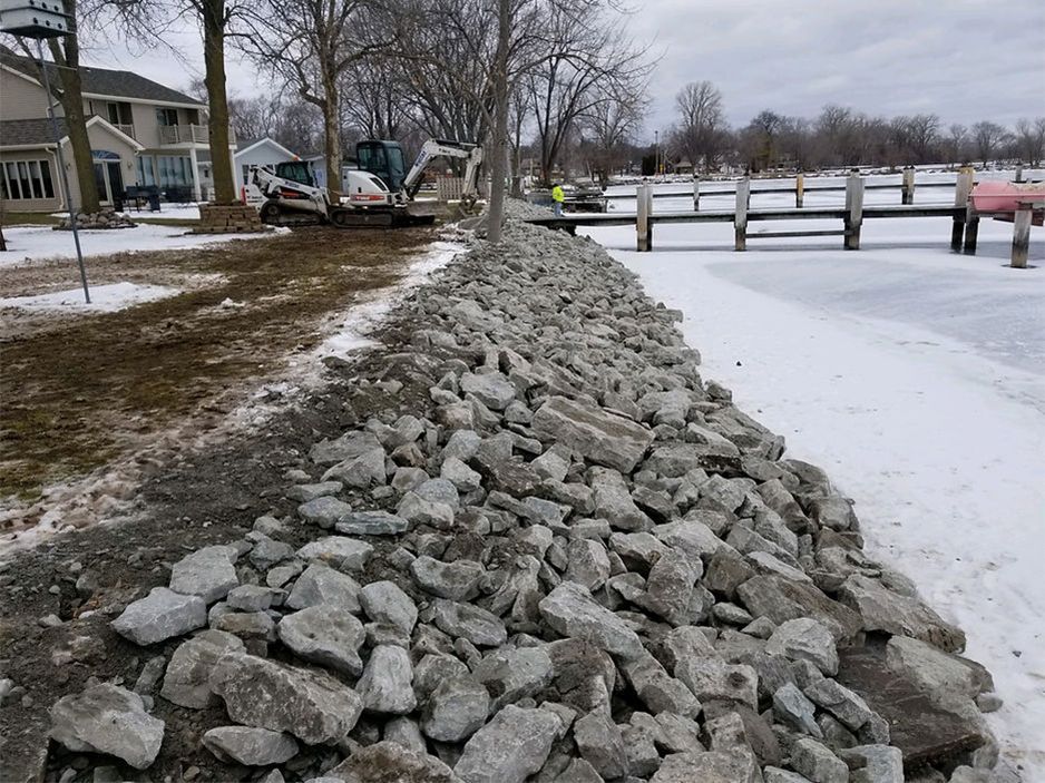 A river with a dock and a lot of rocks on the shore - after