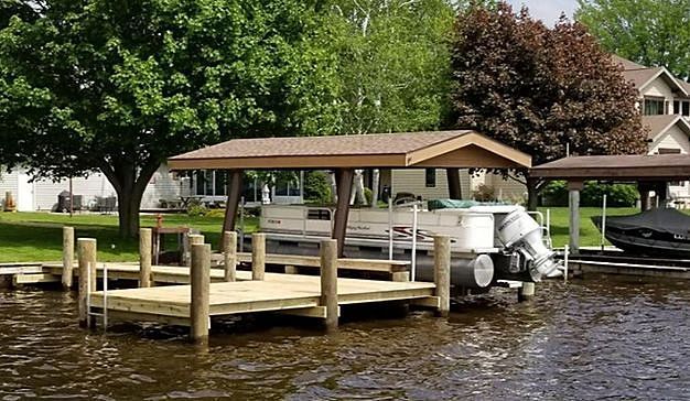 A boat is docked at a dock next to a house.