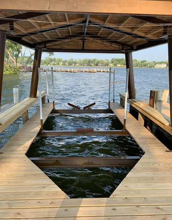 A wooden dock with a boat in the water.