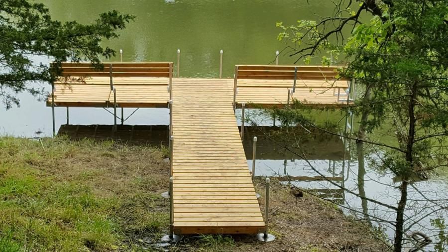 A wooden dock is installed on the shore of a lake.