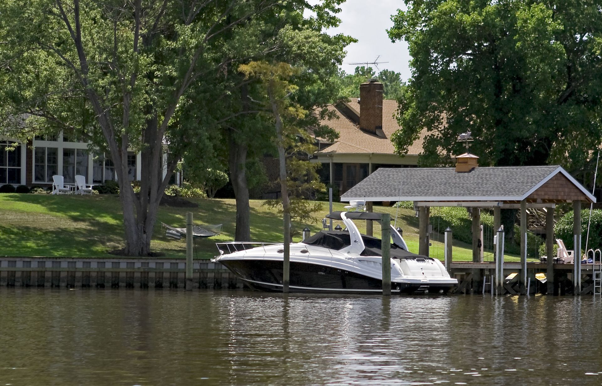 A boat is docked at a dock next to a house