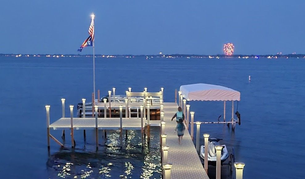 A boat is docked at a dock with fireworks in the background