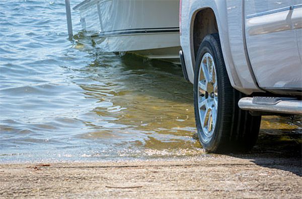 A truck is towing a boat into the water.