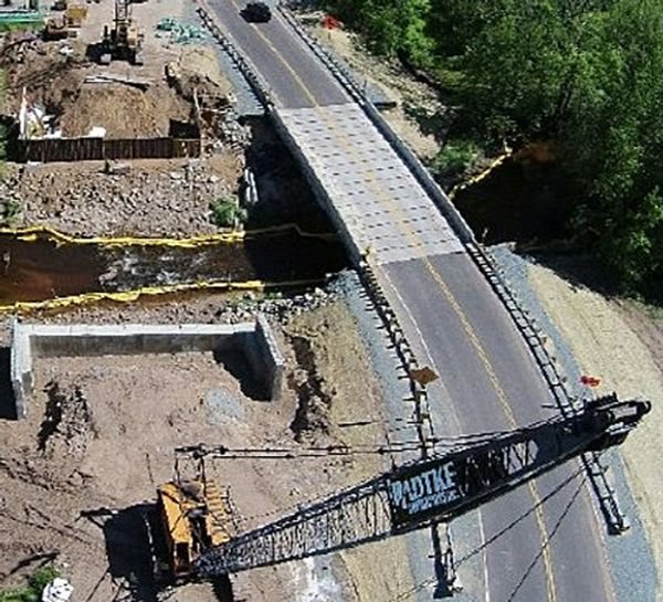 An aerial view of a bridge under construction with a crane that says motke on it