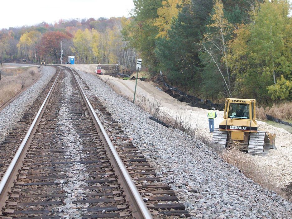 A train track with a yellow bulldozer on it